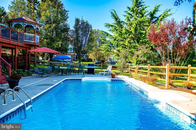 a view of outdoor space with green field and trees in the background