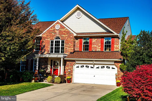 a view of a white house with large windows and a yard