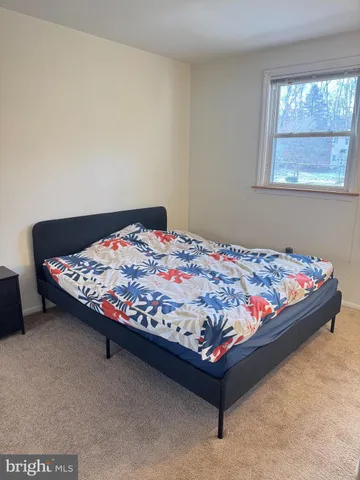 a bed sitting in a bedroom next to a window