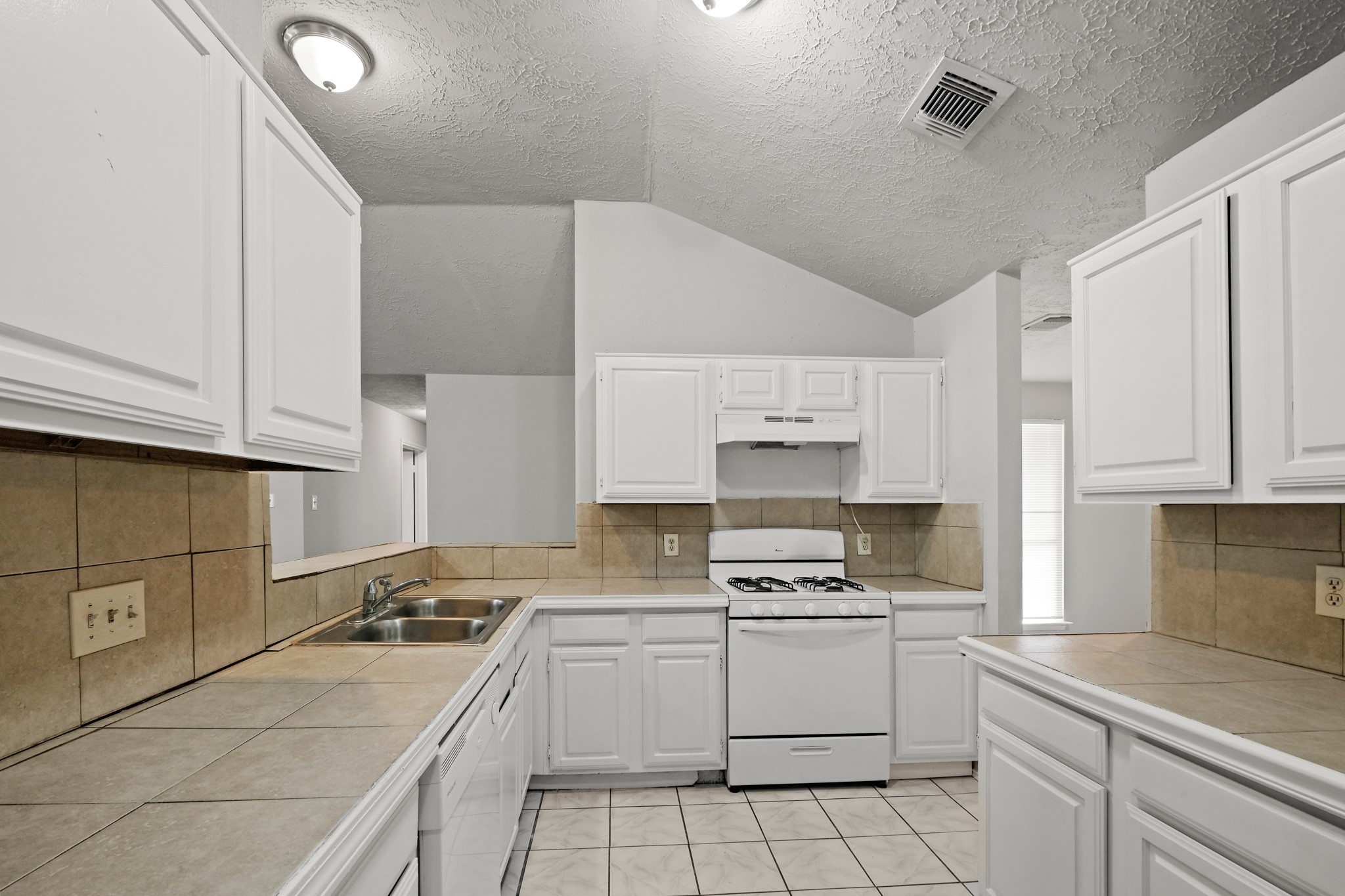 6607 Navidad Road Houston, TX 77083 - Photo 3 of 11 a kitchen with cabinets appliances a sink and a counter top space