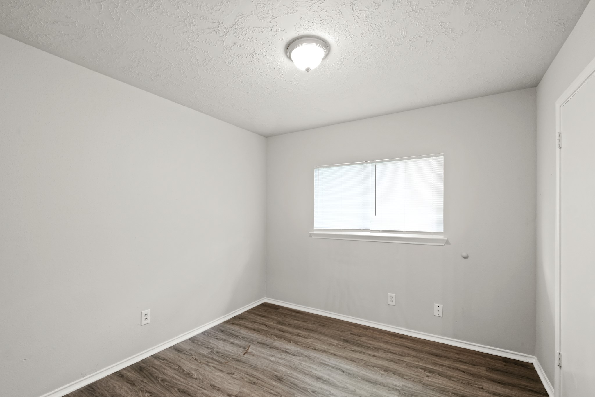 6607 Navidad Road Houston, TX 77083 - Photo 4 of 11 an empty room with wooden floor and windows