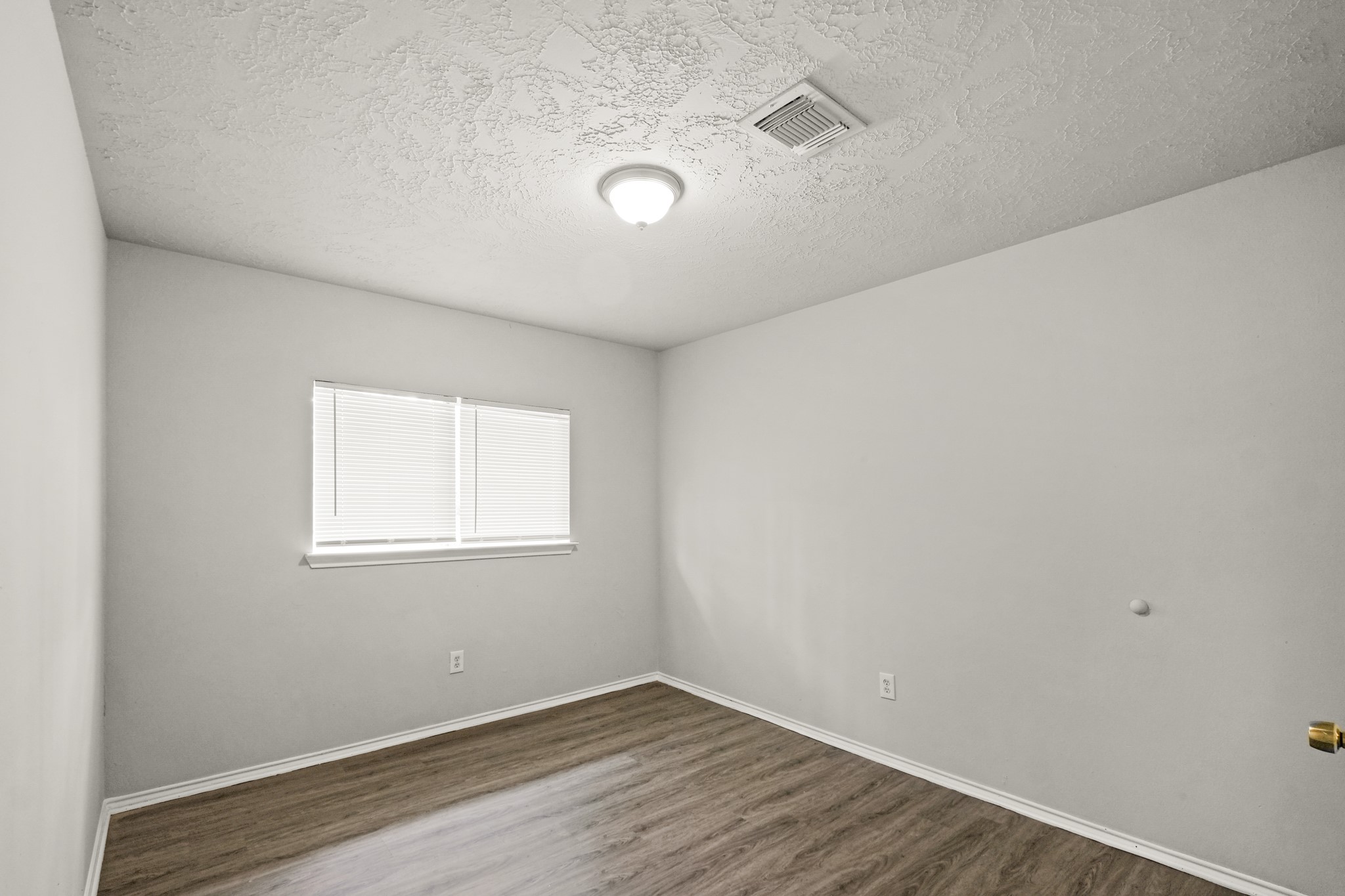 6607 Navidad Road Houston, TX 77083 - Photo 6 of 11 an empty room with wooden floor and windows