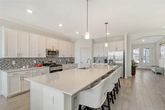 a kitchen with stainless steel appliances granite countertop a stove a sink and a refrigerator