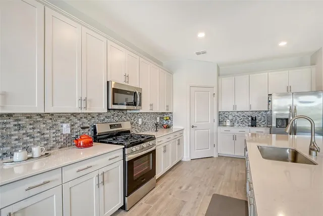 a large kitchen with kitchen island a sink a stove a dining table and chairs
