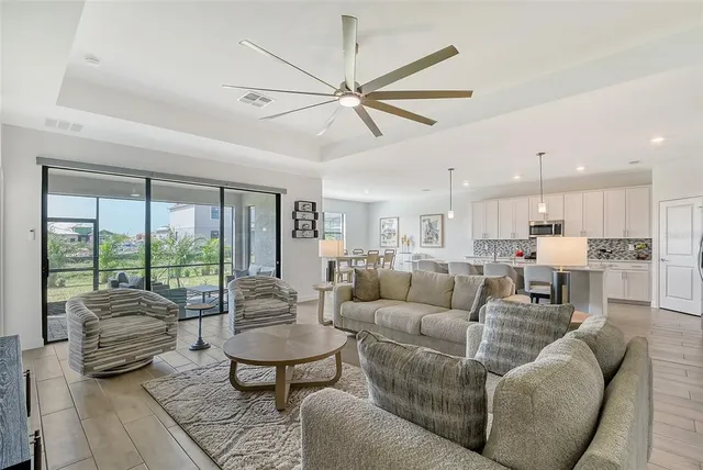 a living room with furniture a flat screen tv and a large window
