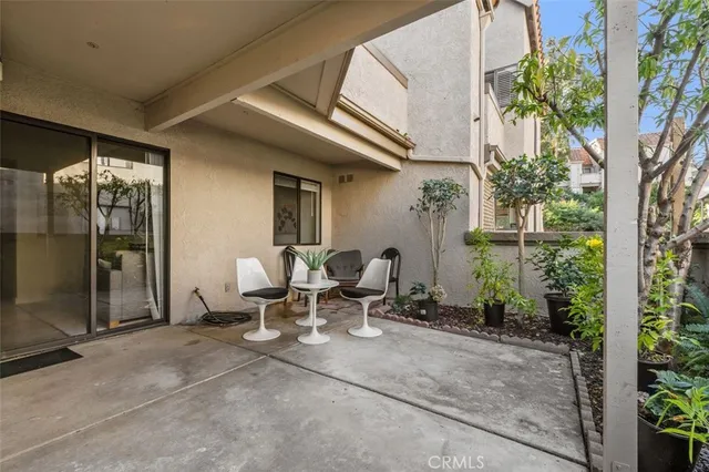 a view of a patio with table and chairs and potted plants