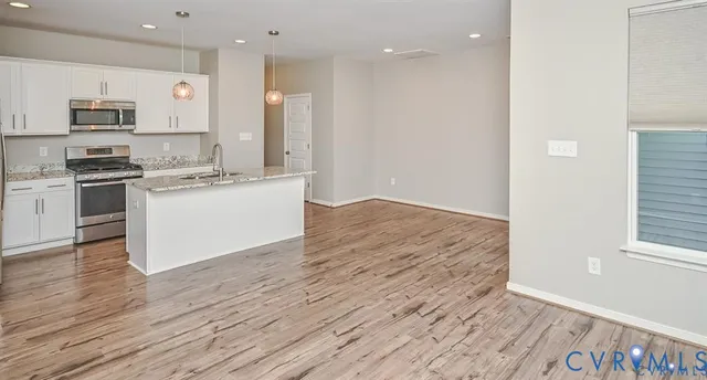 a kitchen with stainless steel appliances granite countertop a stove a sink and a refrigerator