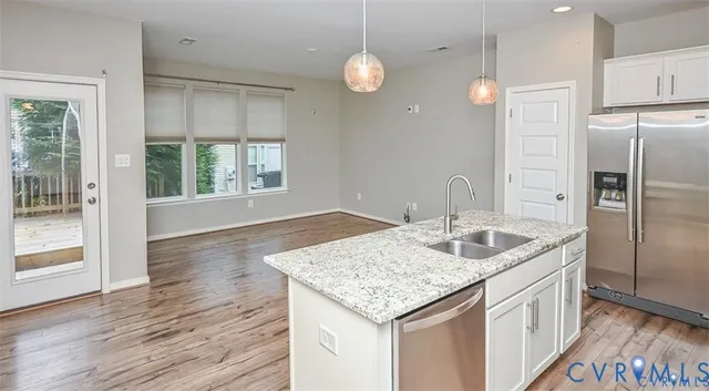 a kitchen with granite countertop a sink and refrigerator