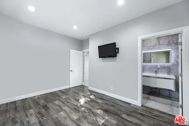 a view of a livingroom with wooden floor and a flat screen tv