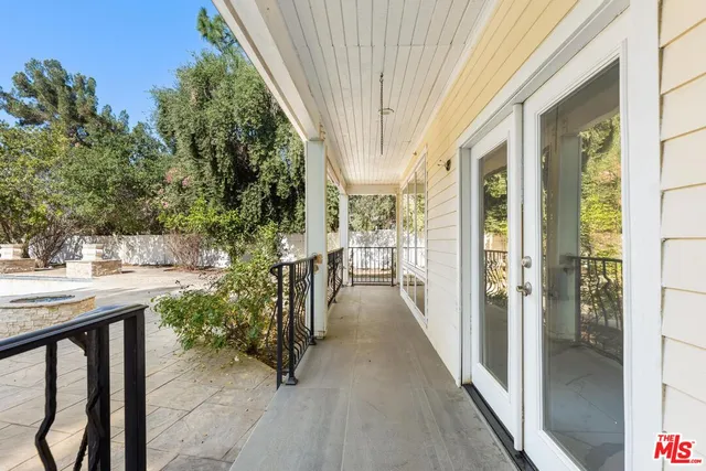 a view of a white house with large windows next to a road