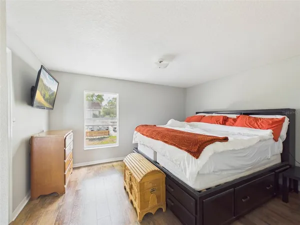 a bedroom with a bed and wooden floor