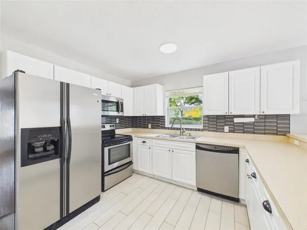 a kitchen with a white cabinets and stainless steel appliances