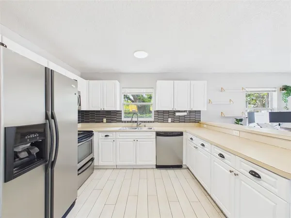 a kitchen with cabinets oven and white appliances