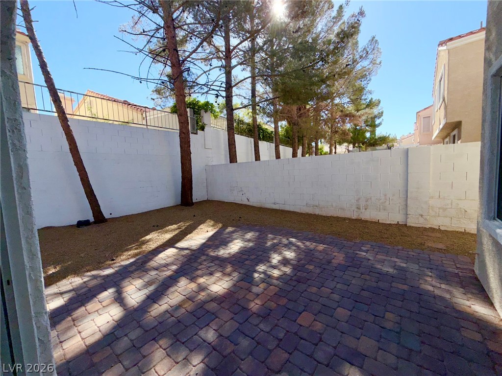 9729 Trail Rider Drive Las Vegas, NV 89117 - Photo 23 of 26 Enjoy outdoor living with a spacious paver patio and mature trees providing natural shade.
