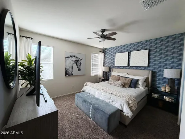 a bedroom with a bed and a flat tv screen on dresser