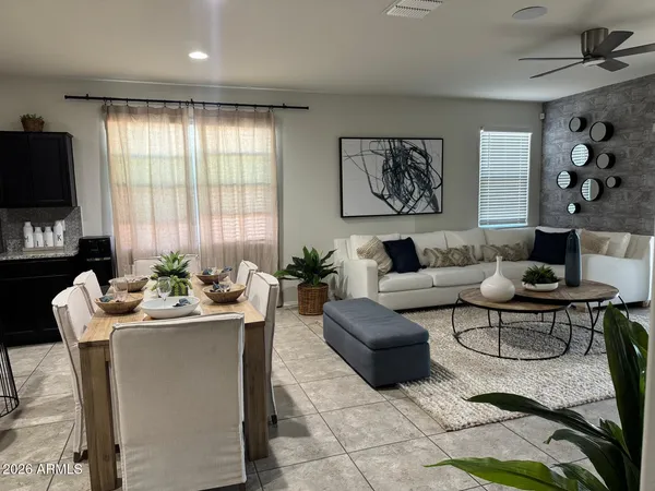 a living room with furniture a flat screen tv and a large window