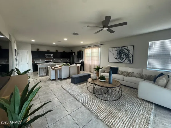 a living room with furniture kitchen view and a window