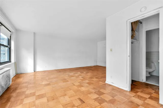 a view of a hallway with a livingroom and a bathroom