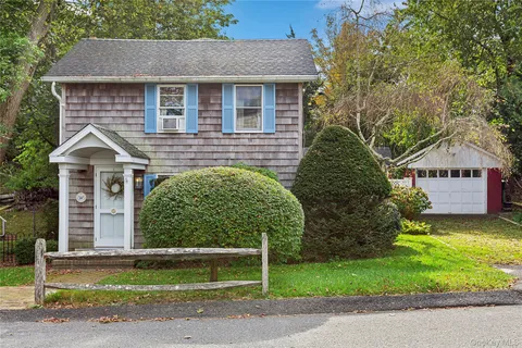 a front view of a house with a garden and plants