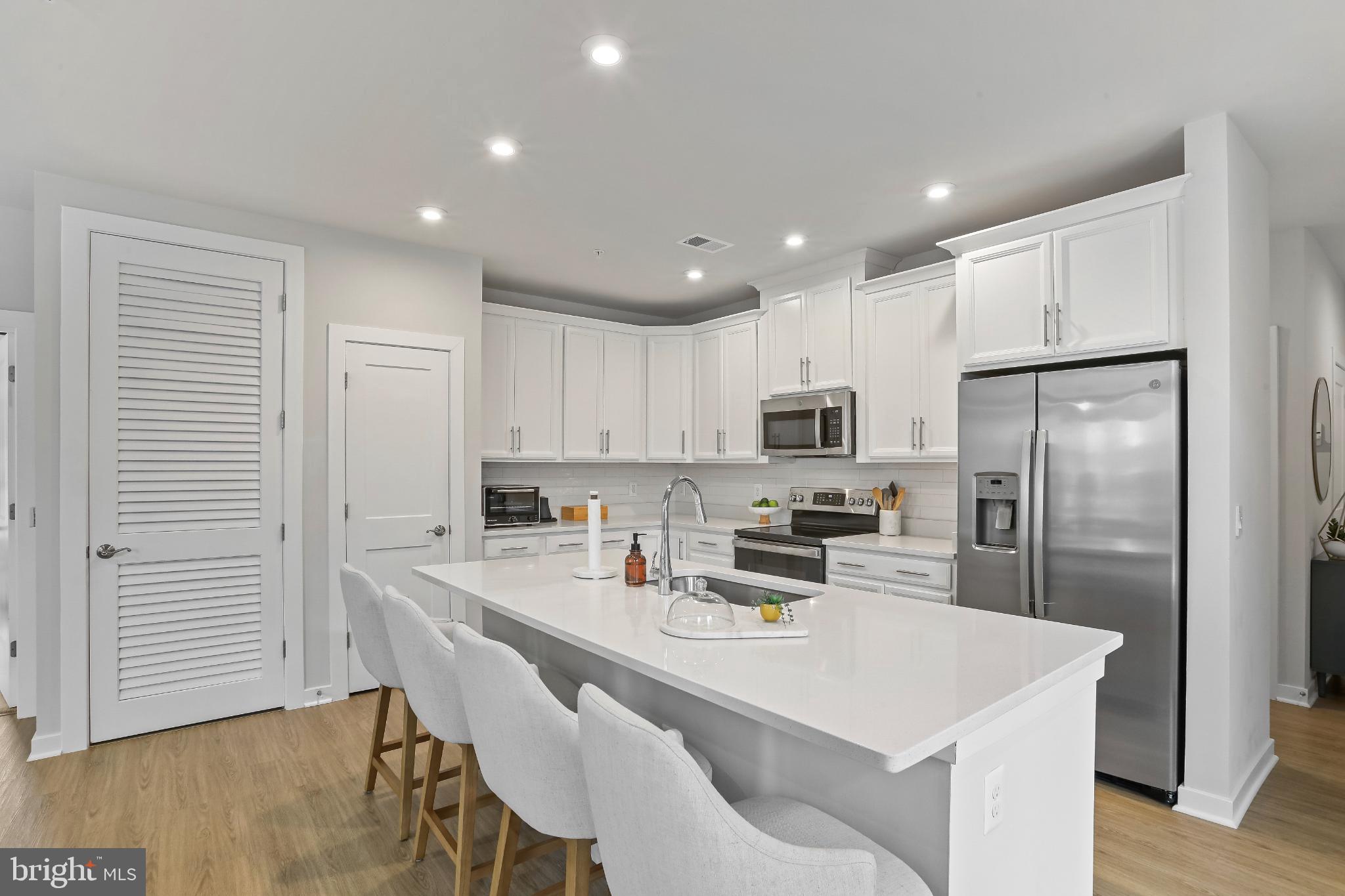 1675 Bandit Loop, Unit 201B Reston, VA 20190 - Photo 3 of 27 a kitchen that has a lot of white cabinets and stainless steel appliances