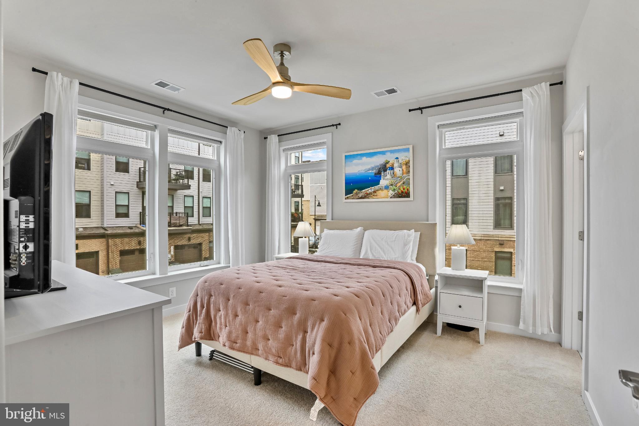 1675 Bandit Loop, Unit 201B Reston, VA 20190 - Photo 8 of 27 a bedroom with a large bed and a chandelier