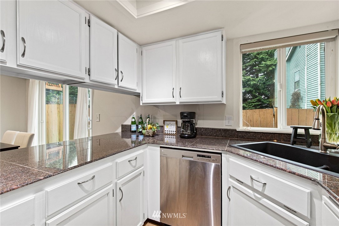 18505 20th Drive Southeast Bothell, WA 98012 - Photo 14 of 35 a kitchen with granite countertop a sink stainless steel appliances white cabinets and a window
