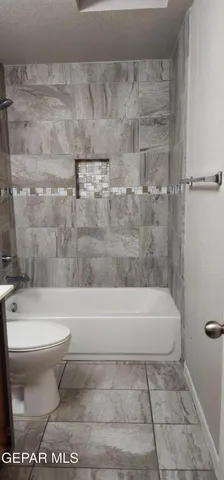 a white bath tub sitting next to a white toilet