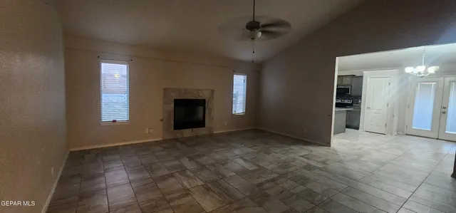 an empty room with windows and fireplace