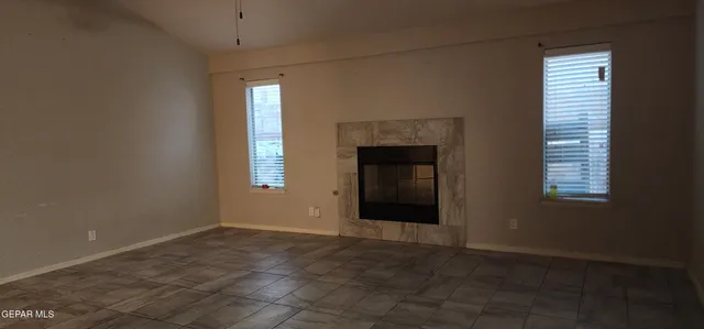 a view of an empty room with a window and fireplace