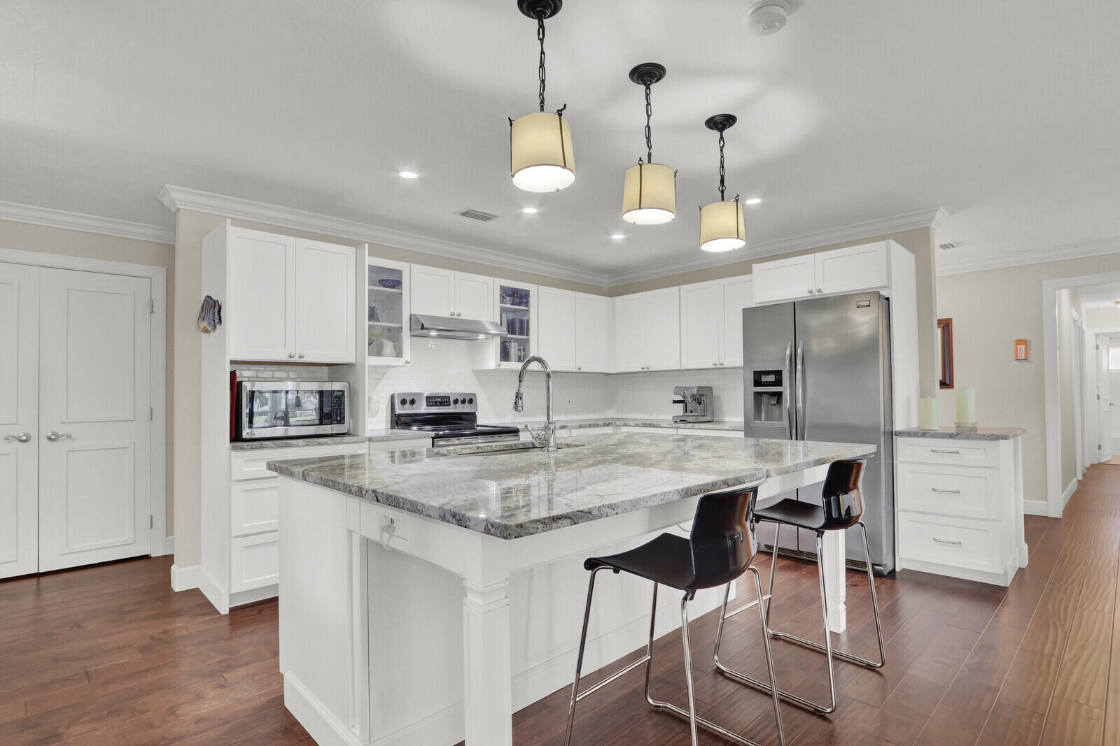 3060 Southeast Darien Road Port St. Lucie, FL 34952 - Photo 5 of 56 a kitchen with stainless steel appliances granite countertop a stove top oven a refrigerator a sink and a island with wooden floor