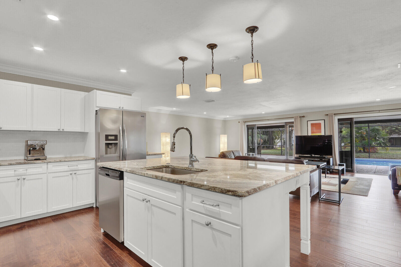 3060 Southeast Darien Road Port St. Lucie, FL 34952 - Photo 7 of 56 a kitchen with a stove a sink a kitchen island with chairs and wooden floor