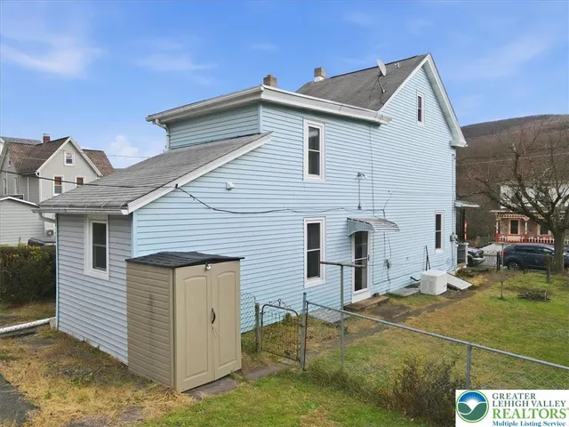 a view of a white house next to a yard