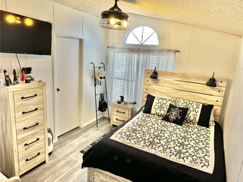 8811 Park Street, Unit 54 Bellflower, CA 90706 - Photo 11 of 13 a bedroom with a bed and a flat tv screen on the dresser