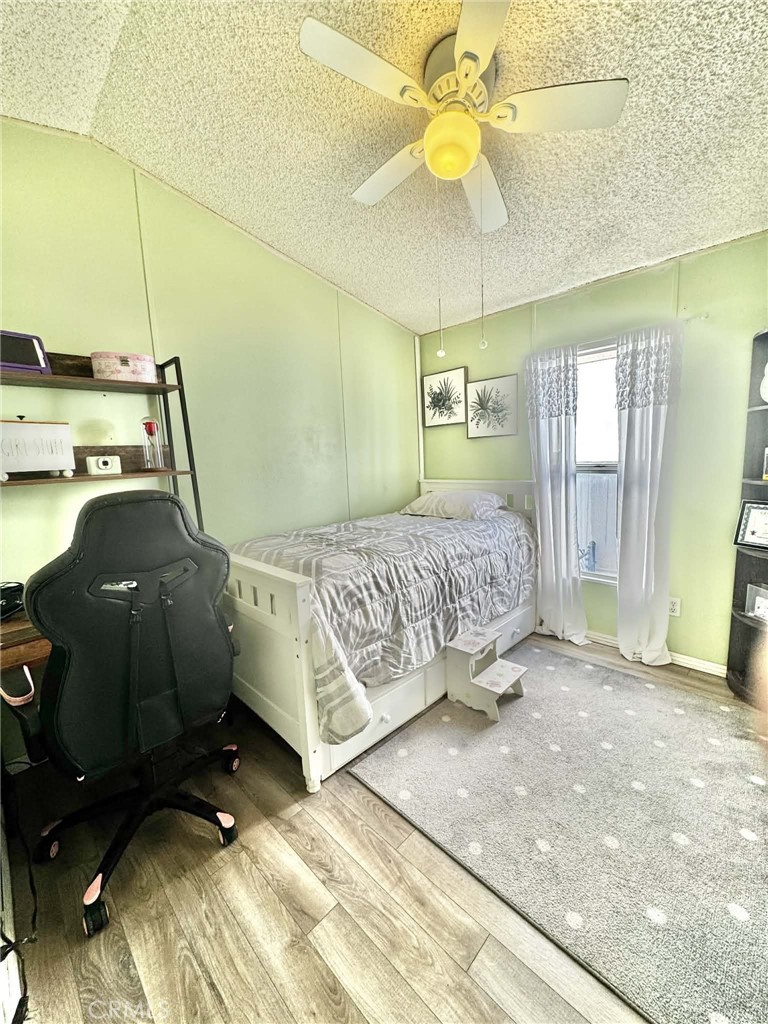 8811 Park Street, Unit 54 Bellflower, CA 90706 - Photo 12 of 13 a bedroom with a bed and a chandelier