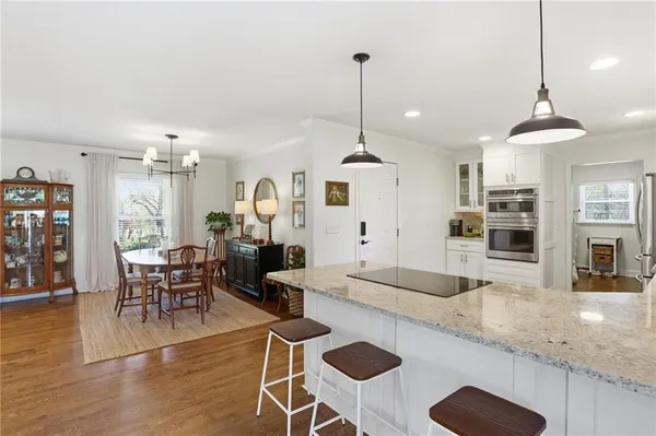 a large kitchen with sink a refrigerator and chairs