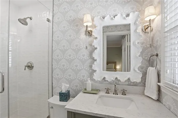 a bathroom with a sink vanity mirror and toilet