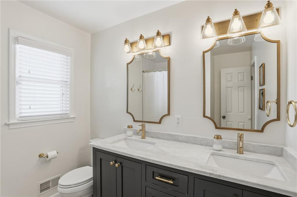 555 Allgood Road Northeast Marietta, GA 30060 - Photo 19 of 32 a bathroom with a double vanity sink toilet and a mirror