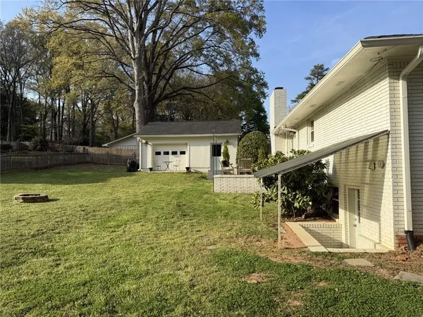 a view of a house with backyard and sitting area