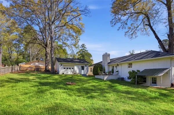 a view of a house with a big yard and large trees