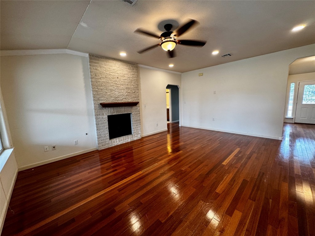 104 Silk Tree Lane Round Rock, TX 78664 - Photo 5 of 29 a view of an empty room with wooden floor and a ceiling fan