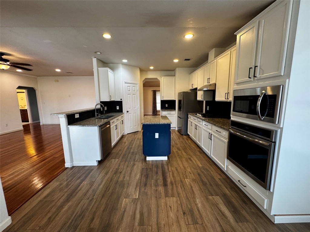 104 Silk Tree Lane Round Rock, TX 78664 - Photo 9 of 29 a kitchen with stainless steel appliances kitchen island granite countertop a stove top oven and sink