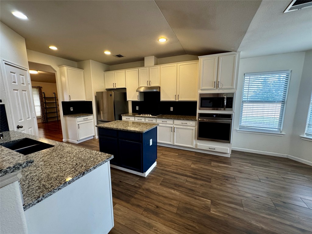 104 Silk Tree Lane Round Rock, TX 78664 - Photo 10 of 29 a kitchen with kitchen island granite countertop stainless steel appliances and wooden cabinets