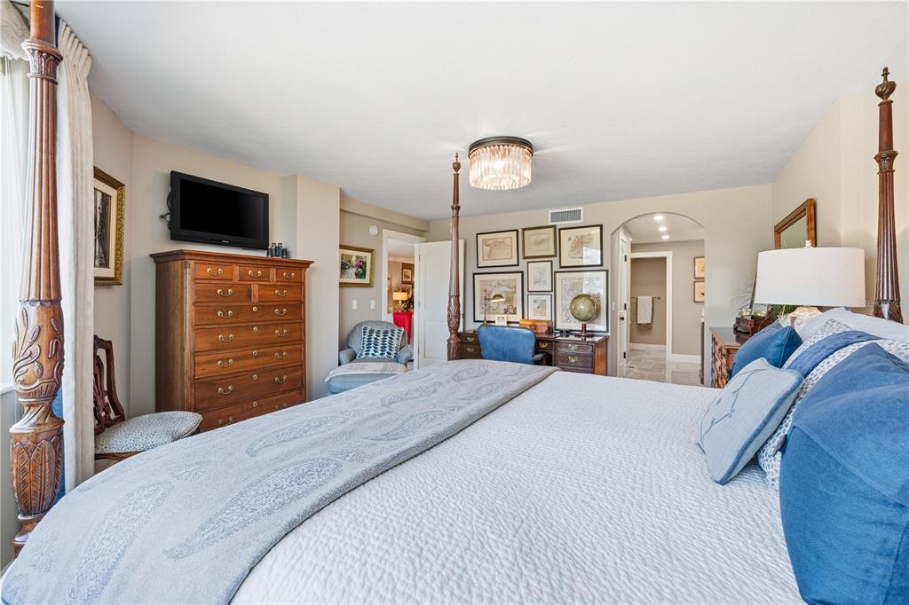 5880 Midnight Pass Road, Unit 302 Sarasota, FL 34242 - Photo 31 of 97 a bedroom with a bed and a flat tv screen on wall