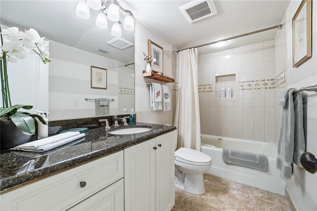 5880 Midnight Pass Road, Unit 302 Sarasota, FL 34242 - Photo 39 of 97 a bathroom with a granite countertop sink a toilet a mirror and shower