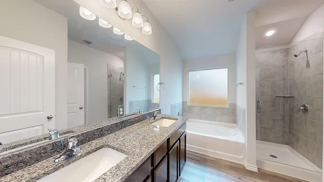 a bathroom with a granite countertop bathtub a sink and a mirror