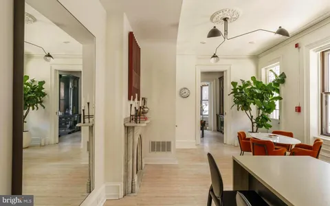 a kitchen with stainless steel appliances kitchen island granite countertop a refrigerator a stove and a wooden floors