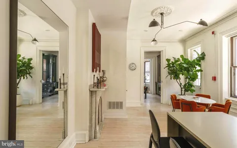 a kitchen with stainless steel appliances kitchen island granite countertop a refrigerator a stove and a wooden floors