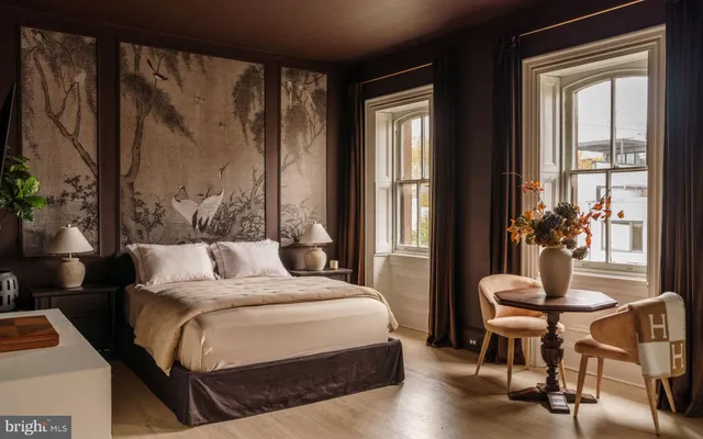 a bedroom with a bed and large windows