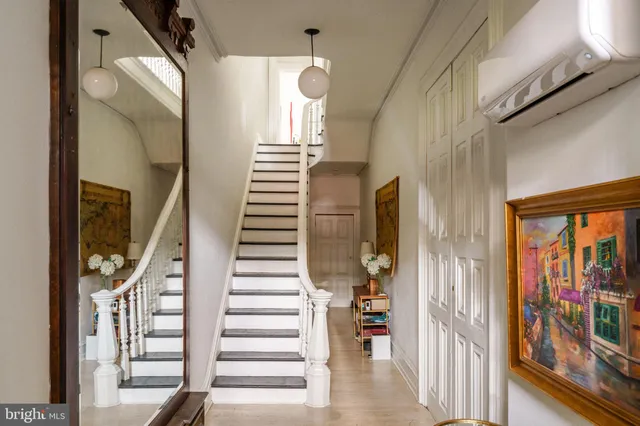 a view of staircase with lots of frames on wall and a large window