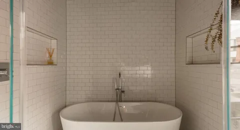 a bedroom with a bed and large windows